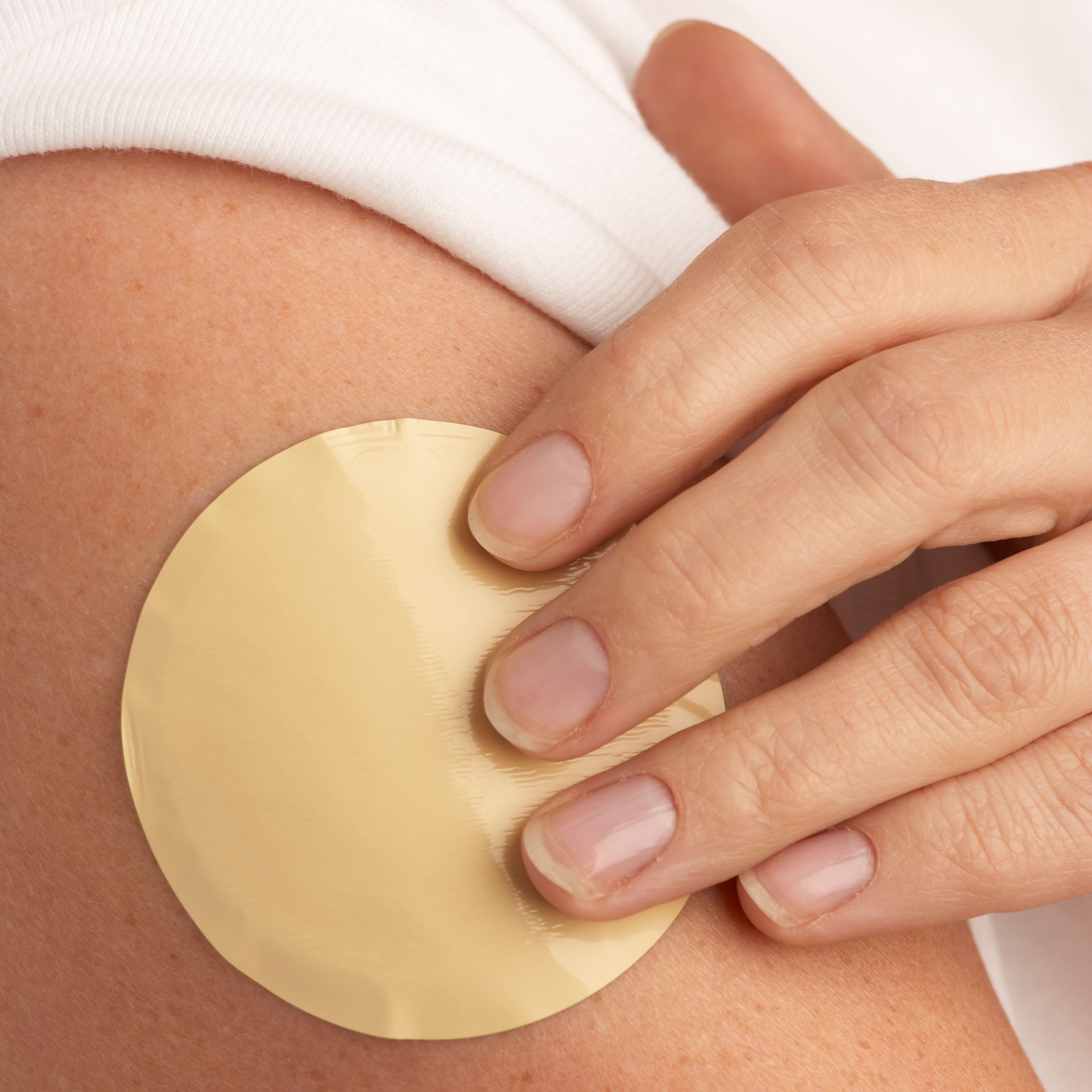 Woman applying nicotine patch to arm